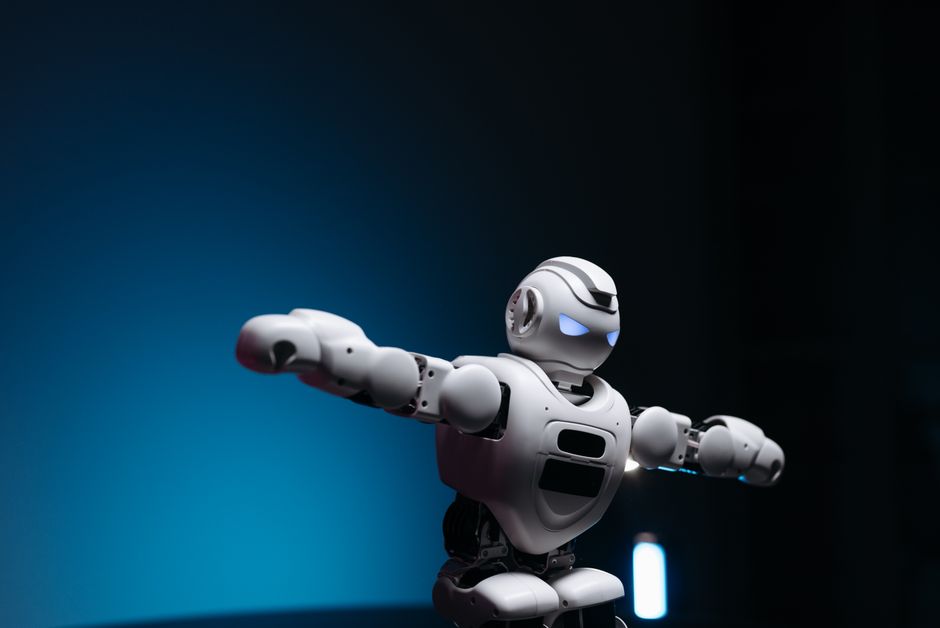 Close-up of a futuristic robot toy with glowing eyes against a blue background, symbolizing innovation.